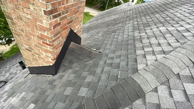 New step flashing properly integrated with shingles at chimney base