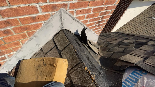 Deteriorated chimney flashing with old tar and patch material