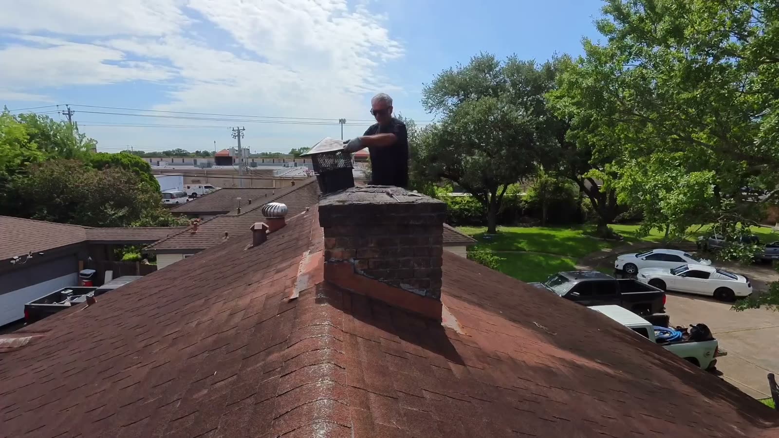 Technician installing a new chimney cap on a Houston, TX home